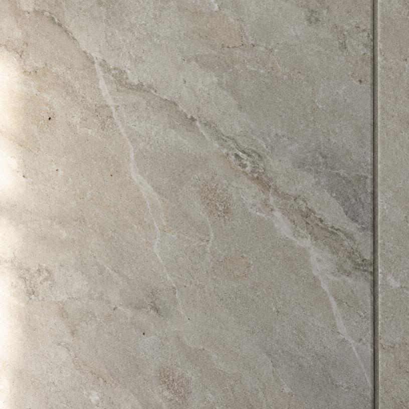 Close-up van een matte keramische tegel met natuursteenlook en zachte aders