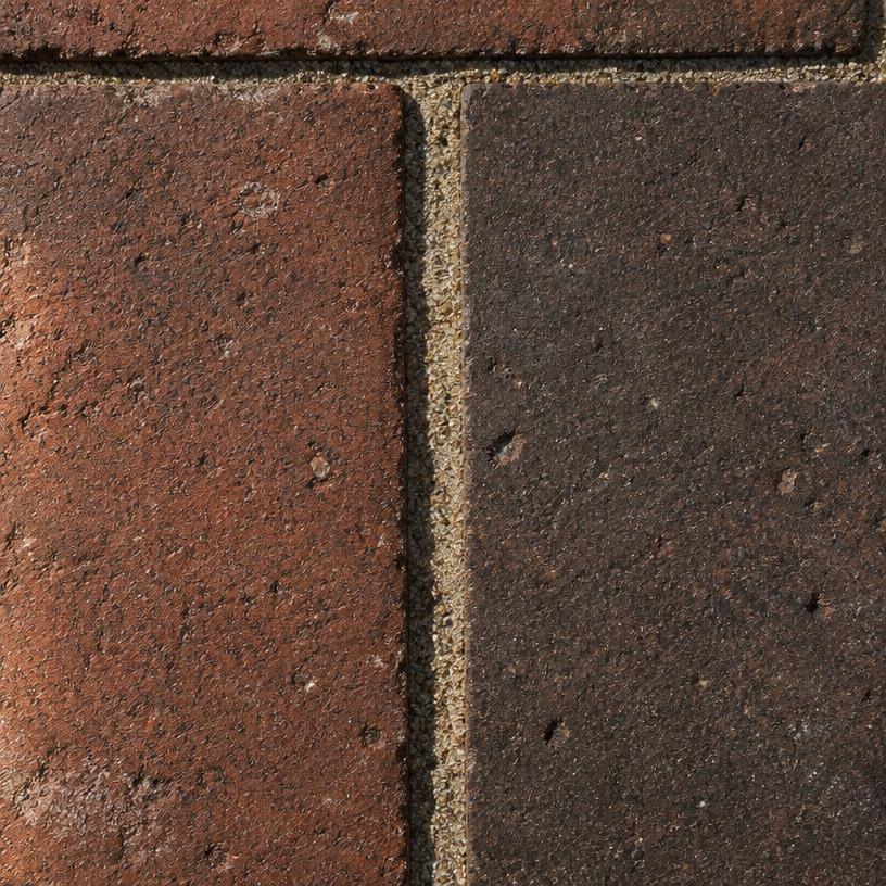 Close-up van roodbruine tot donkerbruine gebakken klinkers met zandvoegen
